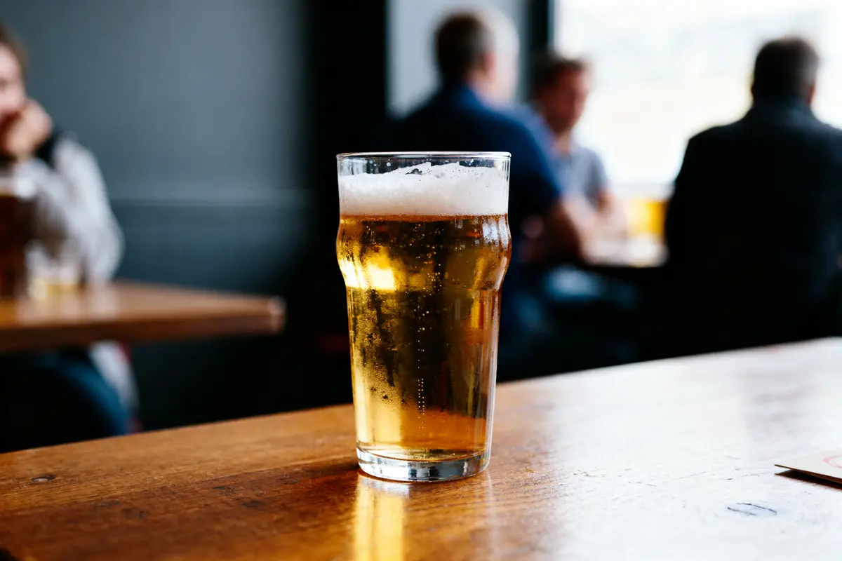 Un verre de bière avec peu d’alcool sur une table en bois d'un café