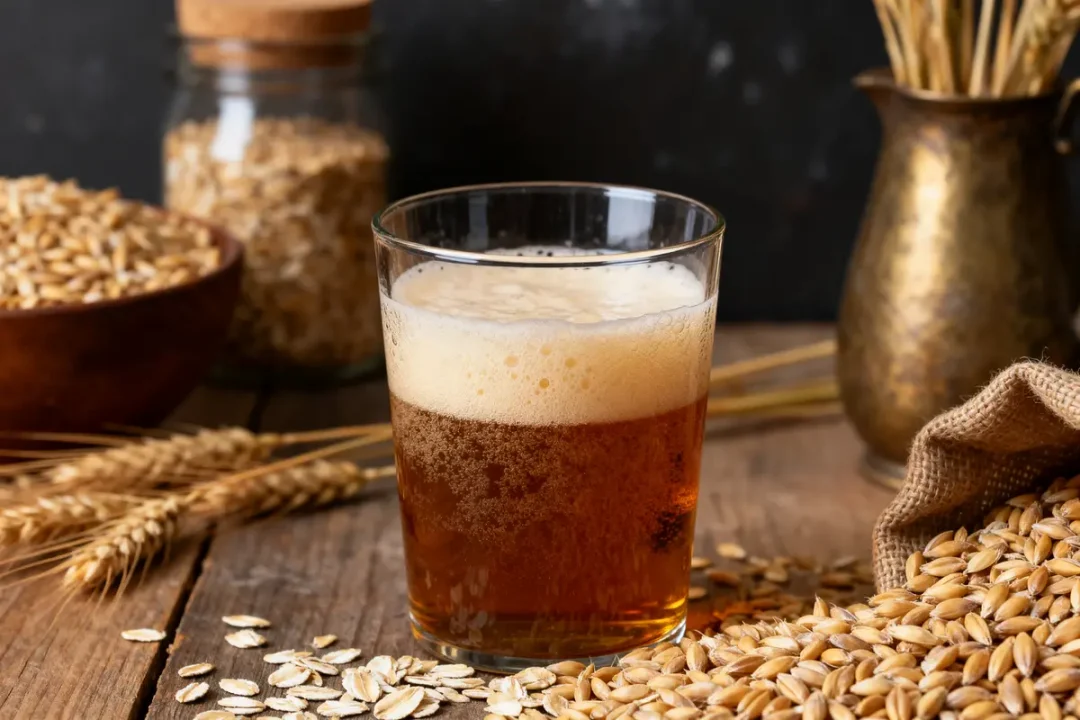 Verre de bière de dégustation ambrée entouré d'ingrédients de brassage artisanaux