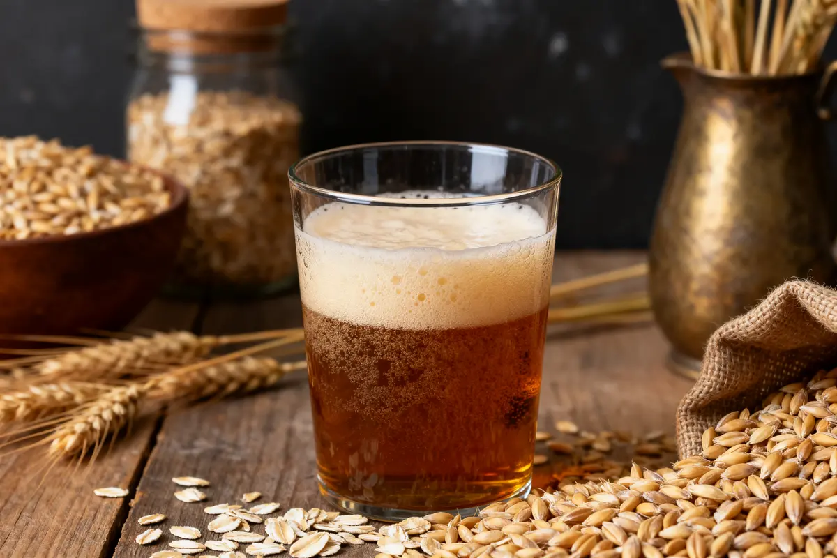 Verre de bière de dégustation ambrée entouré d'ingrédients de brassage artisanaux