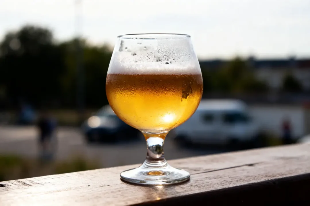 Verre rempli de bière douce pétillante posé sur une table en extérieur