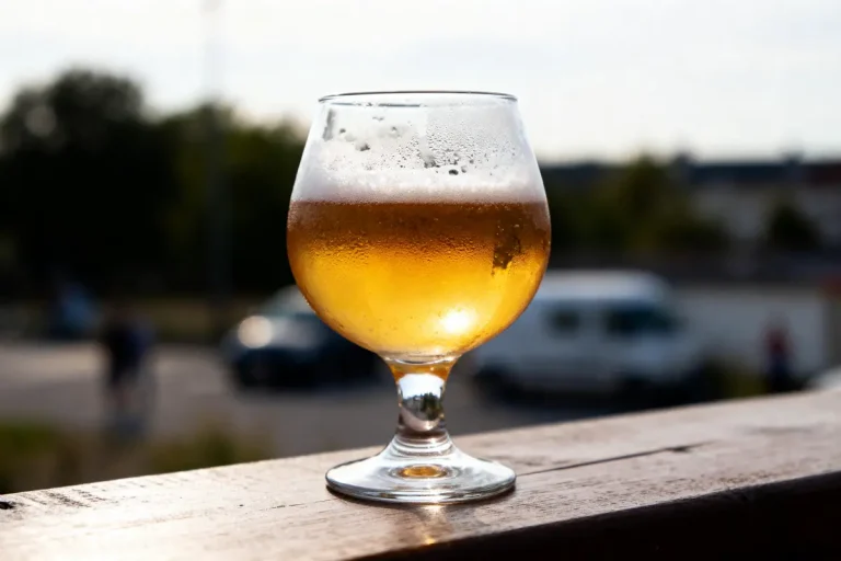Verre rempli de bière douce pétillante posé sur une table en extérieur