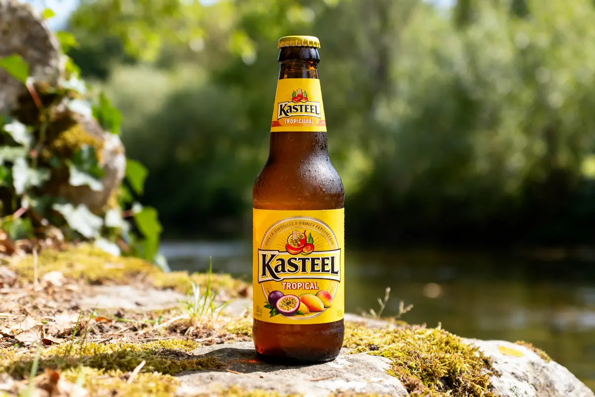 Bouteille de Kasteleel bière tropicale posée sur un rocher près de l'eau